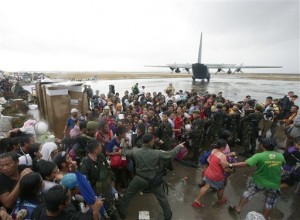 Sobrevivientes del tifón tratan de abordar un avión militar de transporte C-130 en la ciudad de Tacloban. (AP)