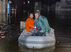 Dos hombres usan una balsa inflattble para desplazarse por una calle inundada en Olbia, en el norte de Cerdeña, Italia,