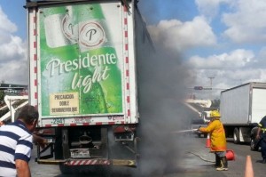 Los Bomberos acudieron al lugar a tratar de apagar el fuego de la patana cargada de cervezas Presidente.


