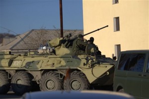 Vehículos blindados que transportan soldados con uniformes sin marcas bloquean el acceso a la base Belbek, cerca de la ciudad portuaria de Sebastopol, Crimea (AP)