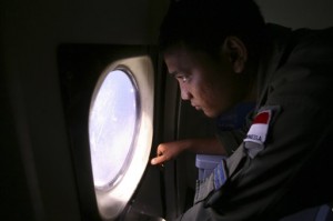 Un tripulante de la marina de guerra indonesia busca rastros de un avión Boeing 777 de Malaysian Airlines desaparecido el lunes 10 de marzo de 2014 cerca del estrecho de Malaca. (Foto AP/Binsar Bakkara)