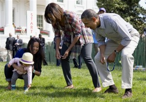 Barack Obama y su esposa Michelle Obama animan a una bebé durante el festejo por la Pascua (AP)
