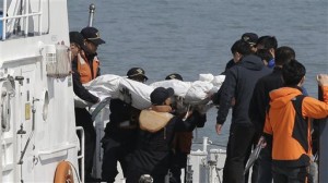 Socorristas cargan el cadáver de un pasajero que iba a bordo del ferry hundido en las costas de Corea del Sur (AP)