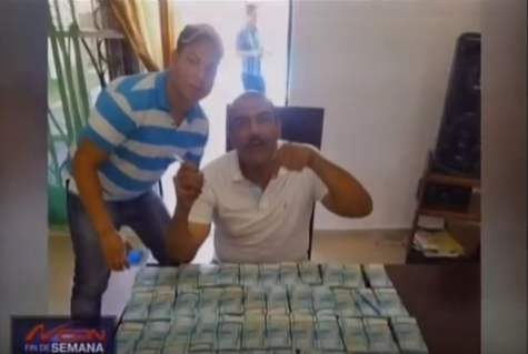 Circula imagen de dos hombres con una mesa llena de billetes de 500 pesos