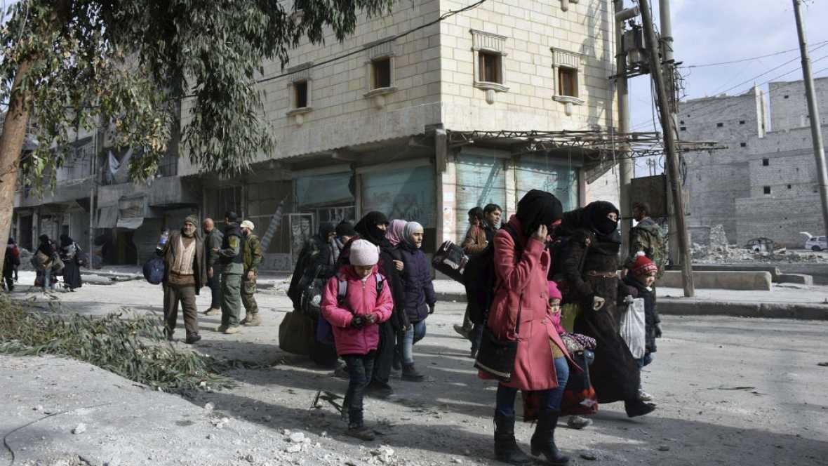 El retraso en la evacuación de civiles y rebeldes prevista para hoy en el este de Alepo (norte de Siria) se ha retrasado por diferencias entre las partes en conflicto, que libran ahora intensos combates en zonas en poder de los opositores. El alto el fuego alcanzado en las últimas horas para la salida de los combatientes y civiles ha saltado por los aires y se desconoce cuando se llevará a cabo la evacuación, que estaba previsto que comenzara a las 05.00 hora local (03.00 hora GMT). Los autobuses que iban a transportar a los rebeldes y civiles evacuados se han retirado y están regresando a sus bases, dijo hoy a Efe el director del Observatorio Sirio de Derechos Humanos, Rami Abderrahman. El embajador ruso ante la ONU, Vitaly Churkin, anunció ayer que el Ejército sirio había detenido sus operaciones en Alepo y que se había llegado a un pacto para la salida de combatientes opositores, pero el cese de hostilidades sólo ha durado unas horas. Según el Observatorio, son las autoridades sirias las que impiden la aplicación del pacto forjado entre Rusia y Turquía para una evacuación por no haber sido consultadas, mientras que los opositores acusan a Irán, porque quiere incluir en el acuerdo algún punto referido a los cercanos pueblos de mayoría chií de Fua y Kefraya. El motivo, según el Observatorio, es que entre los rebeldes hay unos 250 guerrilleros extranjeros que las autoridades sirias quieren detener e investigar, y el hecho de que el Ejército considere que no recibe nada a cambio en este pacto, ya que estaba a punto de tomar totalmente el área rebelde. Hasta ahora, los medios oficiales sirios mantienen el silencio sobre este tema, aunque ni siquiera confirmaron ayer la existencia de un acuerdo para la evacuación. El ministro ruso de Asuntos Exteriores, Serguéi Lavrov, expresó hoy, por su parte, su confianza en que la situación en el oeste de Alepo se resuelva "en los próximos dos o tres días", periodo en el que los guerrilleros que quedan "cesarán la resistencia". Desde Ankara, el ministro de exteriores turco, Mevlüt Çavusoglu, aseguró hoy que en Alepo continúa el fuego cruzado y pidió a todas las partes que respeten la tregua acordada. "Está Rusia, está Irán, hay grupos apoyados por Irán y el régimen (en Alepo). Hay un acuerdo y cada parte debe respetarlo", dijo Çavusoglu, quien explicó que la evacuación de los civiles aún no ha comenzado debido a que continúa el fuego cruzado. "Anoche conversé con el ministro de Asuntos Exteriores de Rusia, (Serguéi) Lavrov, y hablaré hoy con el ministro de Relaciones Exteriores iraní", Mohamad Yavad Zarif, añadió. En paralelo al anuncio en el retraso en la evacuación, estallaron intensos combates entre los efectivos gubernamentales sirios y diversas facciones en las áreas en poder de los opositores en el este de Alepo y en las que están manos de las autoridades, según el Observatorio. Al mismo tiempo, los leales al presidente sirio, Bachar al Asad, disparaban fuego de artillería contra los barrios dominados por los insurgentes, y los rebeldes lanzaban cohetes contra los distritos controlados por las fuerzas gubernamentales en el oeste de Alepo. La ONG destacó que unas 15.000 personas iban a abandonar Alepo, de las que 5.000 eran insurgentes y 10.000 civiles, entre los que hay familiares de combatientes. Según el Centro Ruso para la Reconciliación (CRC) en Siria, casi 5.992 civiles, 2.210 de ellos niños, fueron evacuados en las últimas 24 horas de las zonas controladas por los rebeldes, según dijo un portavoz a la agencia rusa Interfax Además, en el mismo período un total de 366 guerrilleros depusieron las armas y salieron a la parte occidental de Alepo, de los cuales 329 fueron amnistiados "por decisión del presidente" Asad.