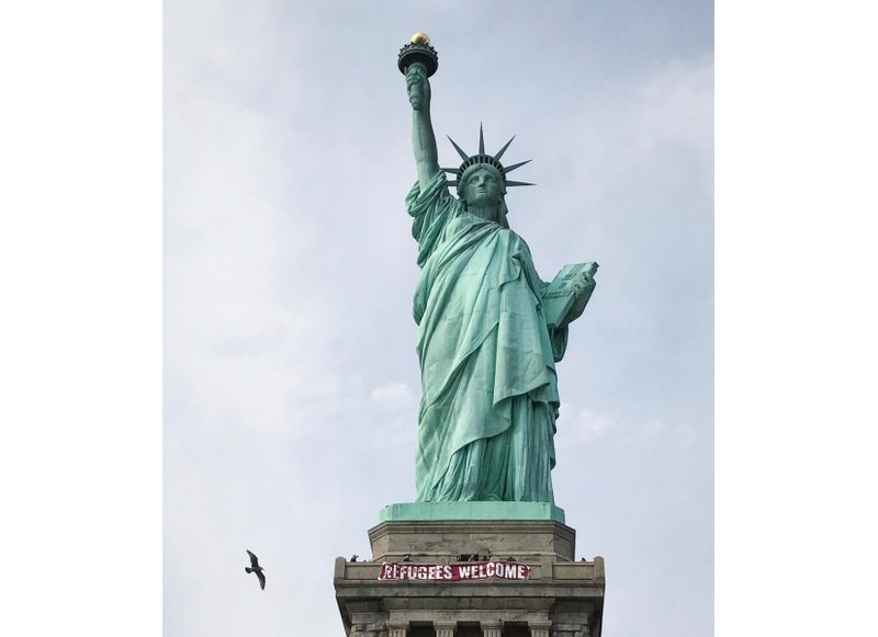 Colocan un cartel sobre refugiados en Estatua de la Libertad