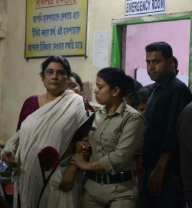 Indian police officials escort Chandana Chakraborty (L) from a police station in Jalpaiguri on February 21, 2017, for a medical check up to a hospital in the district of the eastern Indian state of West Bengal, after her arrest as part of an alleged child trafficking scandal. 
Indian police said that they have arrested the heads of an adoption centre suspected of selling at least 17 children to foreign couples, the latest trafficking scandal to hit the country. Investigators said children aged between six months and 14 years were sold to couples from Europe, America and Asia for between USD 12,000-23,000 and taken out of the country.
 / AFP PHOTO / DIPTENDU DUTTA