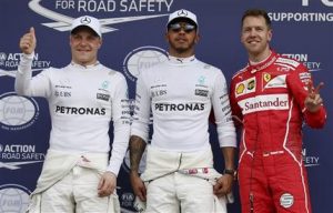 El ganador de la pole del GP de Australia, Lewis Hamilton, centro, posa con el piloto que se clasificó segundo, Sebastian Vettel, derecha, yel tercero Valtteri Bottas, el sábado, 25 de marzo de 2017, en Melbourne. (AP Photo/Rick Rycroft)