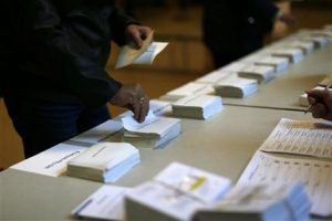 Un hombre selecciona una boleta para la primera ronda de las elecciones presidenciales de Francia de una mesa en un centro electoral en París, el 23 de abril de 2017. (AP Foto/Emilio Morenatti)
