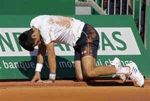 Novak Djokovic cae al suelo durante un partido contra David Goffin por los cuartos de final del Masters de Montecarlo el viernes, 21 de abril de 2017, en Mónaco. (AP Photo/Claude Paris)