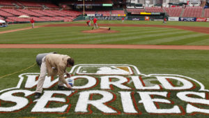 Jim Basler paints a logo on the field at Busch Stadium in preparation for Game 1 of baseball's World Series between the St. Louis Cardinals and the Texas Rangers Tuesday, Oct. 18, 2011, in St. Louis. (AP Photo/Paul Sancya)
