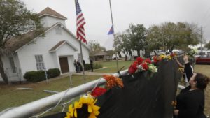Rachel Vasquez places flowers in a fence for the victims of the shooting outside of the Sutherland Springs Baptist Church following a service held at a temporary site, Sunday, Nov. 12, 2017, in Sutherland Springs, Texas. A man opened fire inside the church in the small South Texas community last week, killing more than two dozen. (AP Photo/Eric Gay)