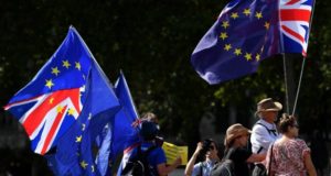 Anti-Brexit activists hold Union and EU flags as they demonstrate opposite the Houses of Parliament in Westminster, London on August 29, 2019. - Prime Minister Boris Johnson's suspension of parliament weeks before Britain's EU departure date faced legal challenges on Thursday following a furious outcry from pro-Europeans and MPs opposed to a no-deal Brexit. (Photo by DANIEL LEAL-OLIVAS / AFP)
