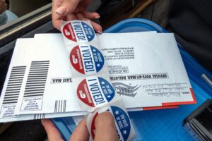 Una persona distribuye unas pegatinas que dicen "Yo voté", que se entregan a las personas tras votar en la puerta de un centro de votación en Miami, Florida (EE.UU.). EFE/Giorgio Viera/Archivo