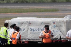 Trabajadores aeroportuarios fueron registrados este jueves al descargar un avión de Aerolíneas Argentinas que trasladó los primeros contenedores de la vacuna rusa Sputnik V contra la covid-19, en el Aeropuerto de Ezeiza en Buenos Aires (Argentina). EFE/Juan Ignacio Roncoroni