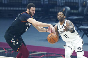 Cleveland Cavaliers' Larry Nance Jr. (22) steals a pass intended for Brooklyn Nets' Kyrie Irving (11) during the first half of an NBA basketball game, Wednesday, Jan. 20, 2021, in Cleveland. (AP Photo/Tony Dejak)