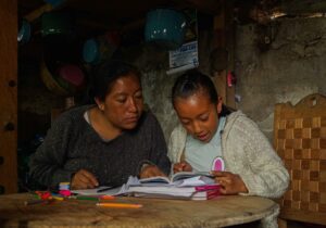 Adriana Pérez (i) ayuda con sus tareas a su hija Yasmin (d) ayer, en San Cristóbal de las Casas, en el estado de Chiapas (México). EFE/ Carlos López