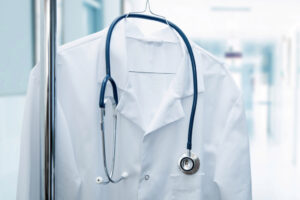 job vacancy - white doctor coat on hanger in hospital hallway