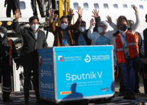 El presidente de Boliva, Luis Arce, (2i) saluda junto a un contenedor con dosis de la vacuna rusa Sputnik V el 28 de enero de 2021, en el Aeropuerto Internacional de El Alto (Bolivia). EFE/Martin Alipaz