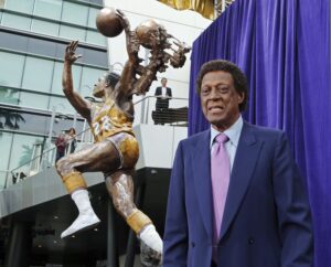 Elgin Baylor stands next to the statue, just unveiled, honoring the Minneapolis and Los Angeles Lakers legend outside Staples Center in Los Angeles Friday, April 6, 2018. XXXX from story. (AP Photo/Reed Saxon)