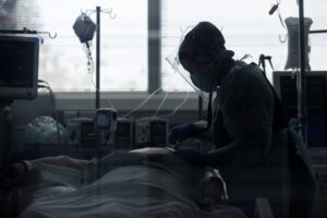 Una trabajadora sanitaria atiende a un paciente afectado por la covid-19,en la Unidad de Cuidados Intensivos del Hospital Clínico de la Universidad de Chile, en Santiago (Chile). EFE/ Alberto Valdés/Archivo