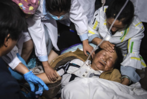 En esta foto publicada por la Agencia de Noticias Xinhua de China, trabajadores médicos tratan a una mujer después de un terremoto en el condado autónomo de Yangbi Yi, en la provincia de Yunnan, suroeste de China, la madrugada del sábado 22 de mayo de 2021. Un par de fuertes terremotos sacudieron dos provincias de China durante la noche del sábado. . (Hu Chao / Xinhua vía AP)