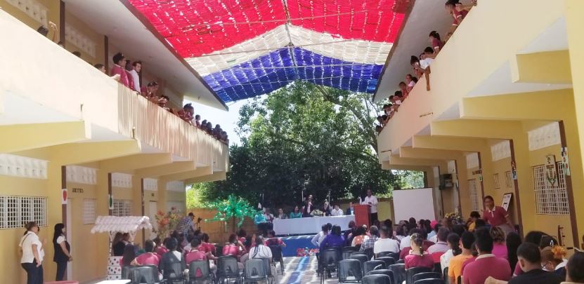 Estudiantes techan salón de escuela con botellas plásticas y colores de la bandera en Nagua